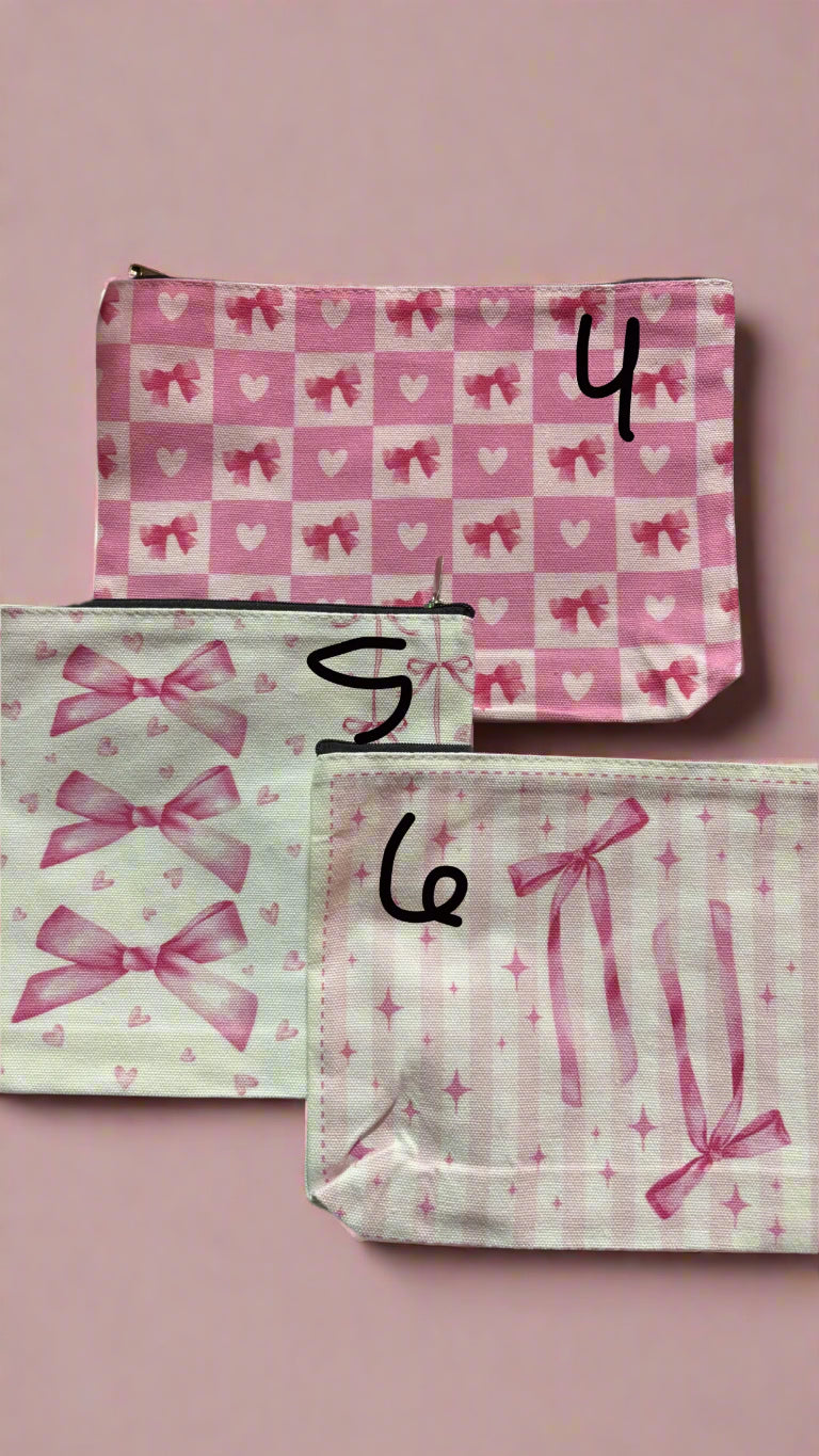 Two pink pouches with bow patterns on a black background